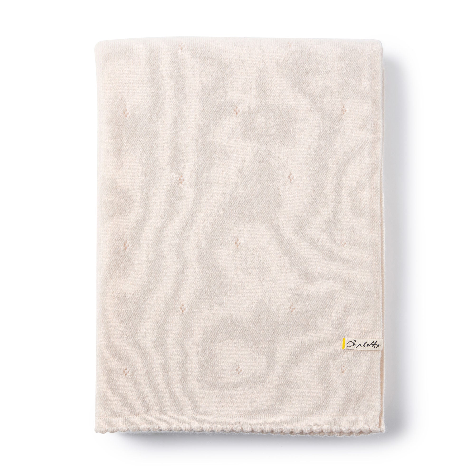 Gefaltete Kaschmirdecke von Chalette in off-white mit Lochmuster auf weißem Hintergrund