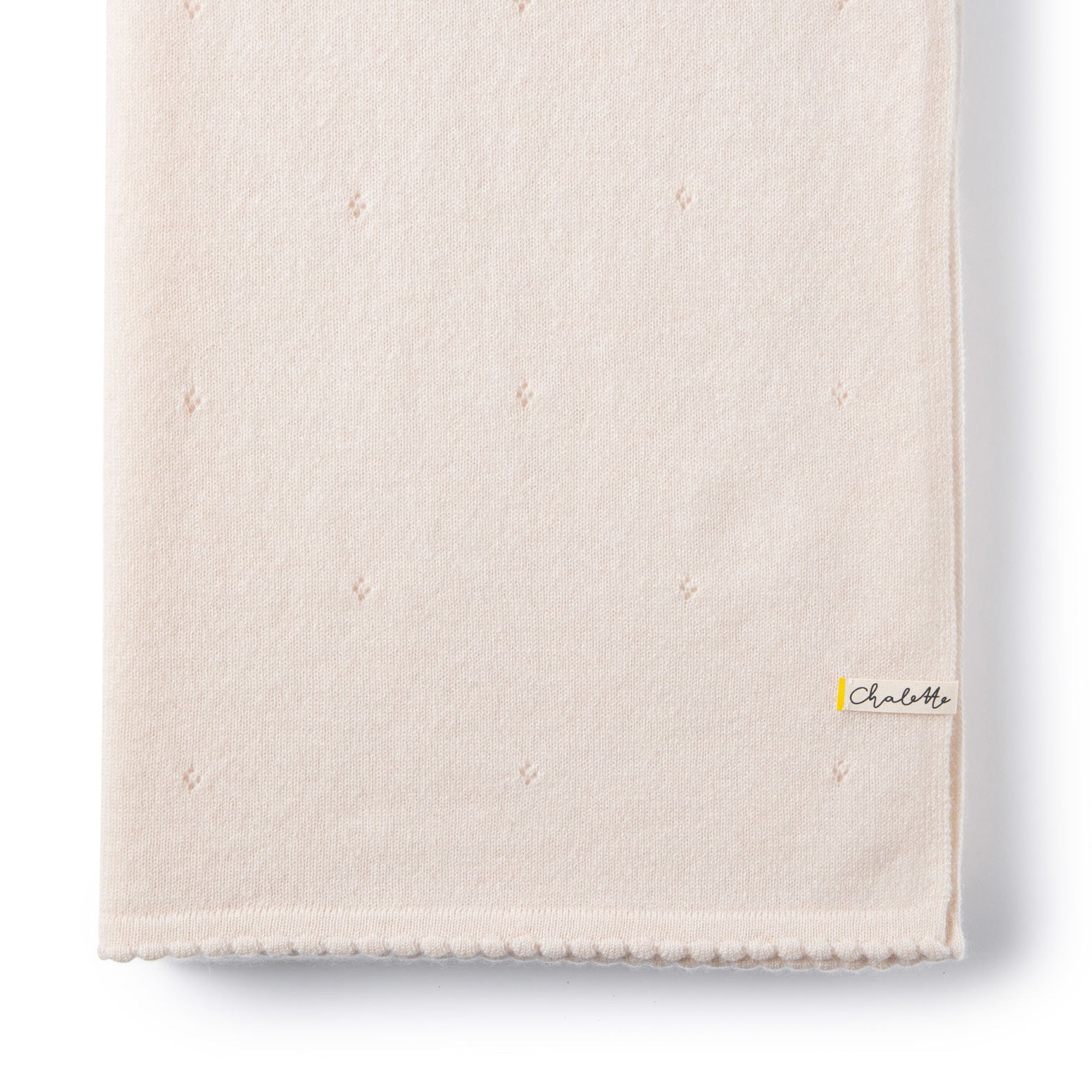 Gefaltete Kaschmirdecke mit Lochmuster in off-white auf weißem Hintergrund