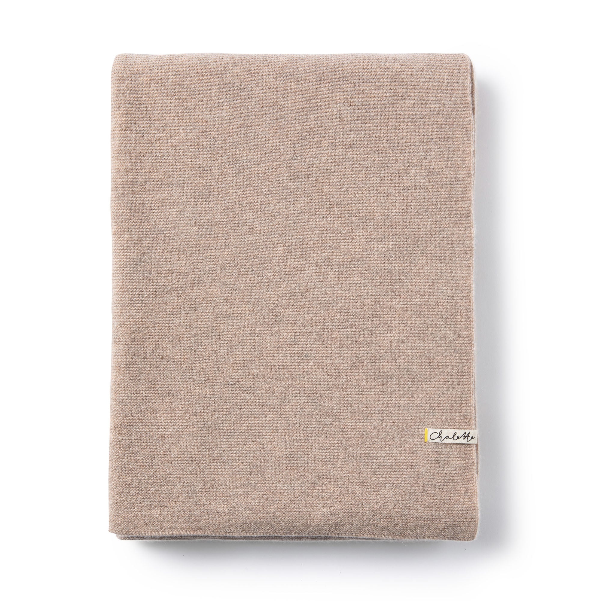 Gefaltete Babydecke in beige auf weißem Hintergrund