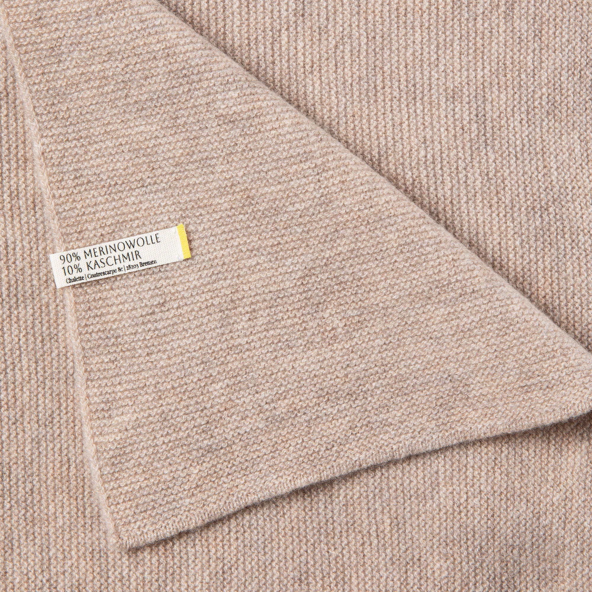 Nahaufnahme einer Babydecke in beige mit feinem Strickmuster