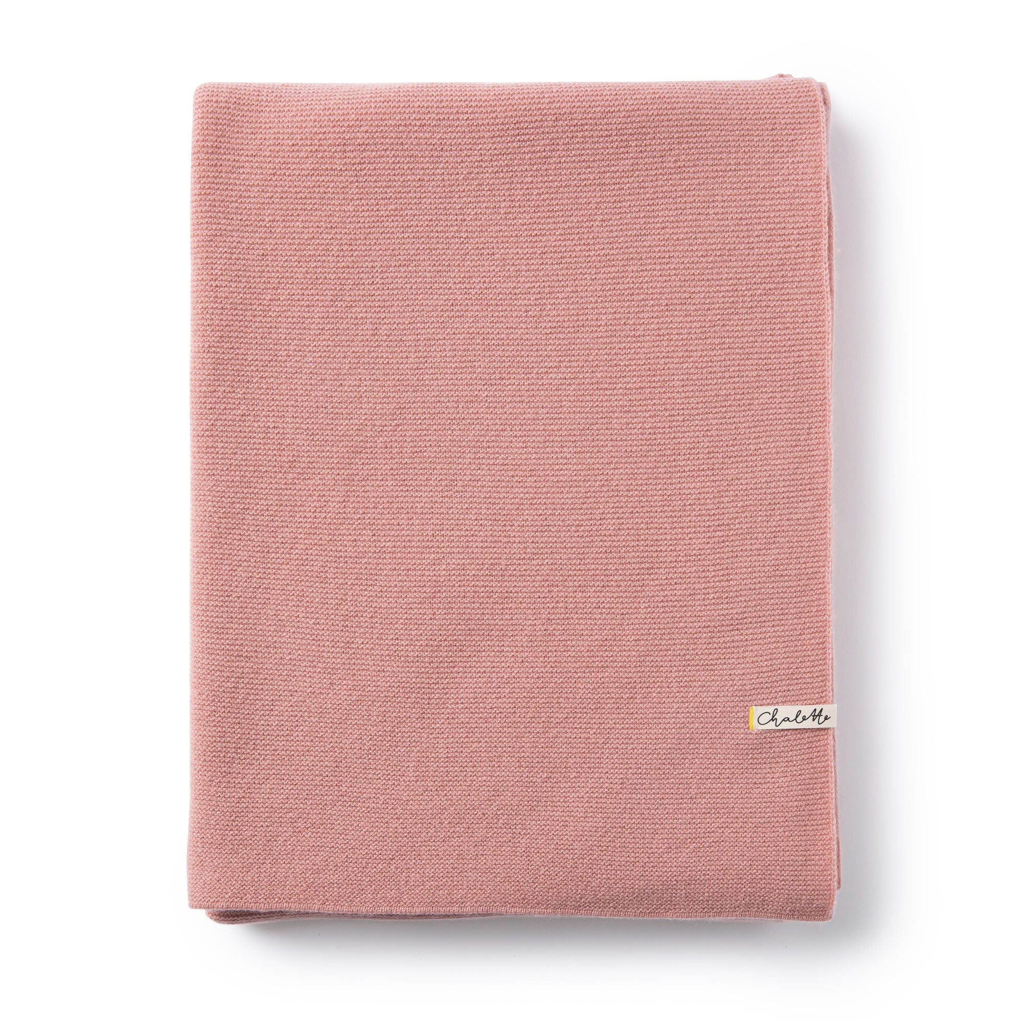 Gefaltete Babydecke in rosa auf weißem Hintergrund