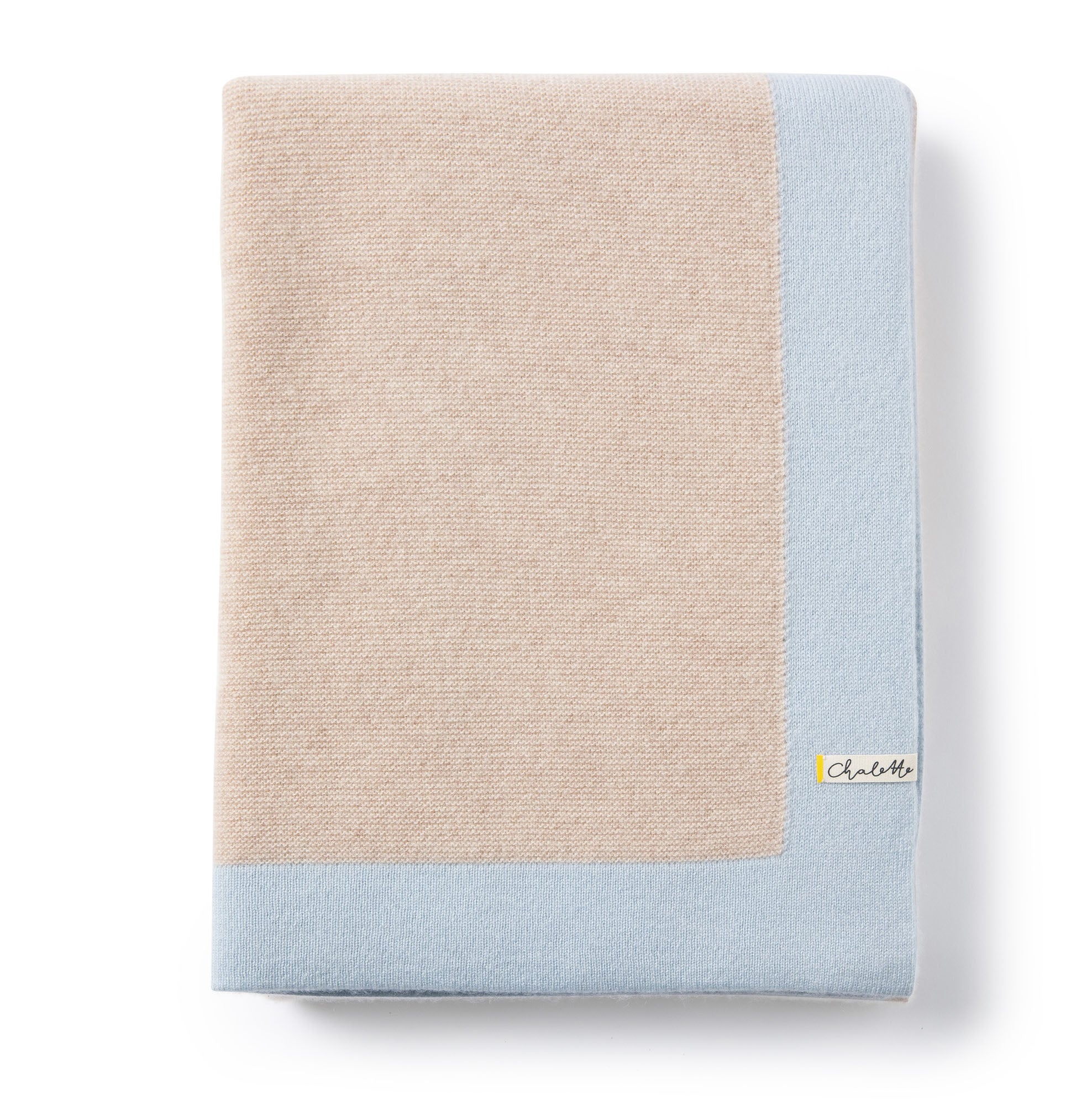 Gefaltete Babydecke in beige mit blauem Rand auf weißem Hintergrund