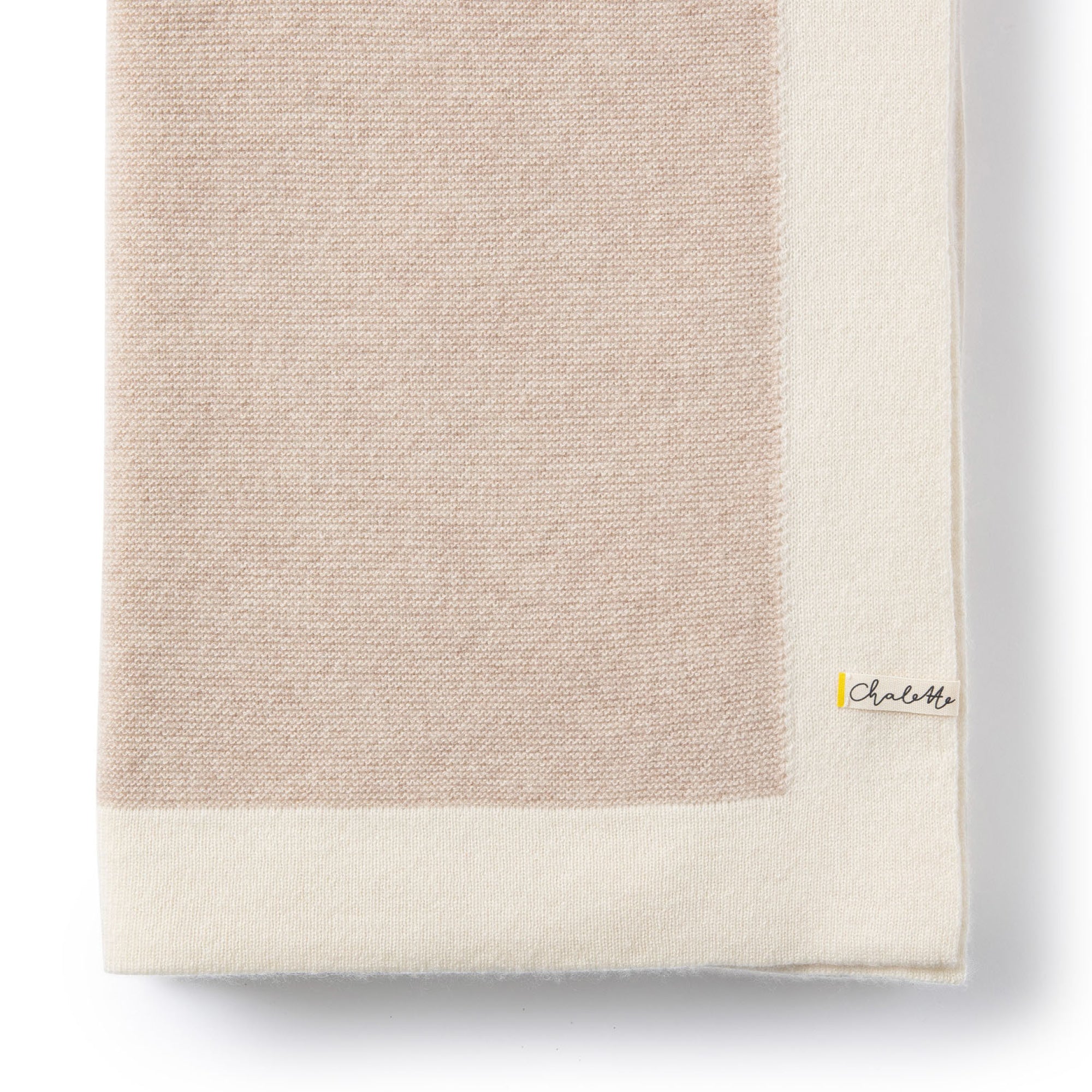 Gefaltete Babydecke aus Kaschmir in beige mit weißem Rand, auf weißem Hintergrund