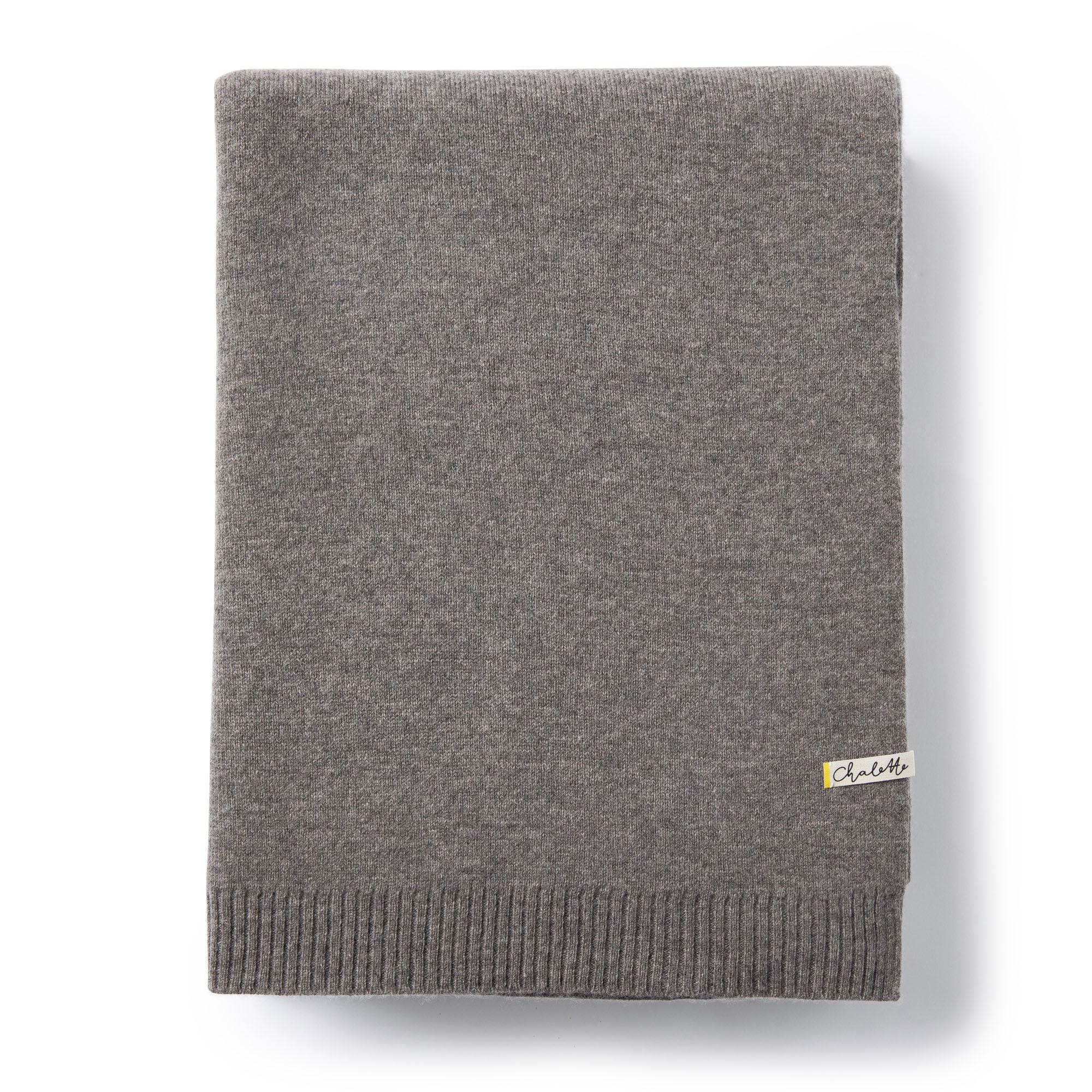 Sofadecke von Chalette in dunkelgrau liegt gefaltet auf weißem Hintergrund