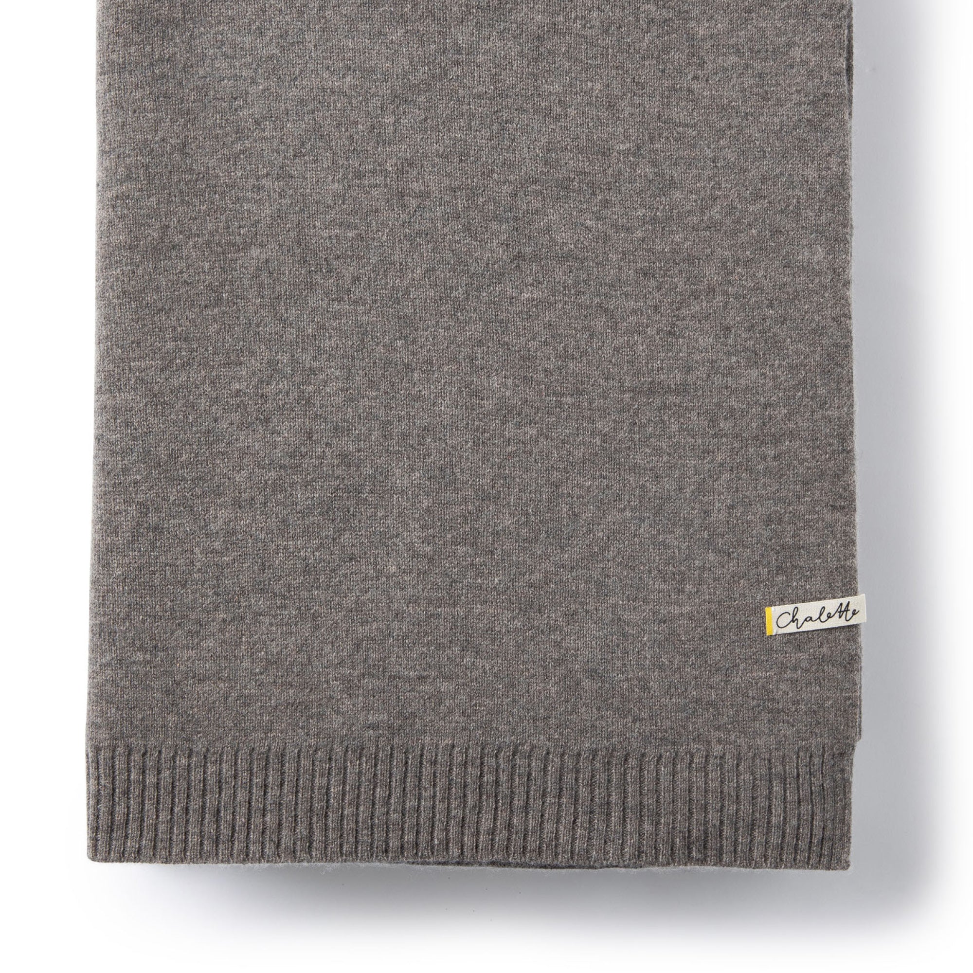 Nahaufnahme einer gefalteten Sofadecke von Chalette in dunkelgrau