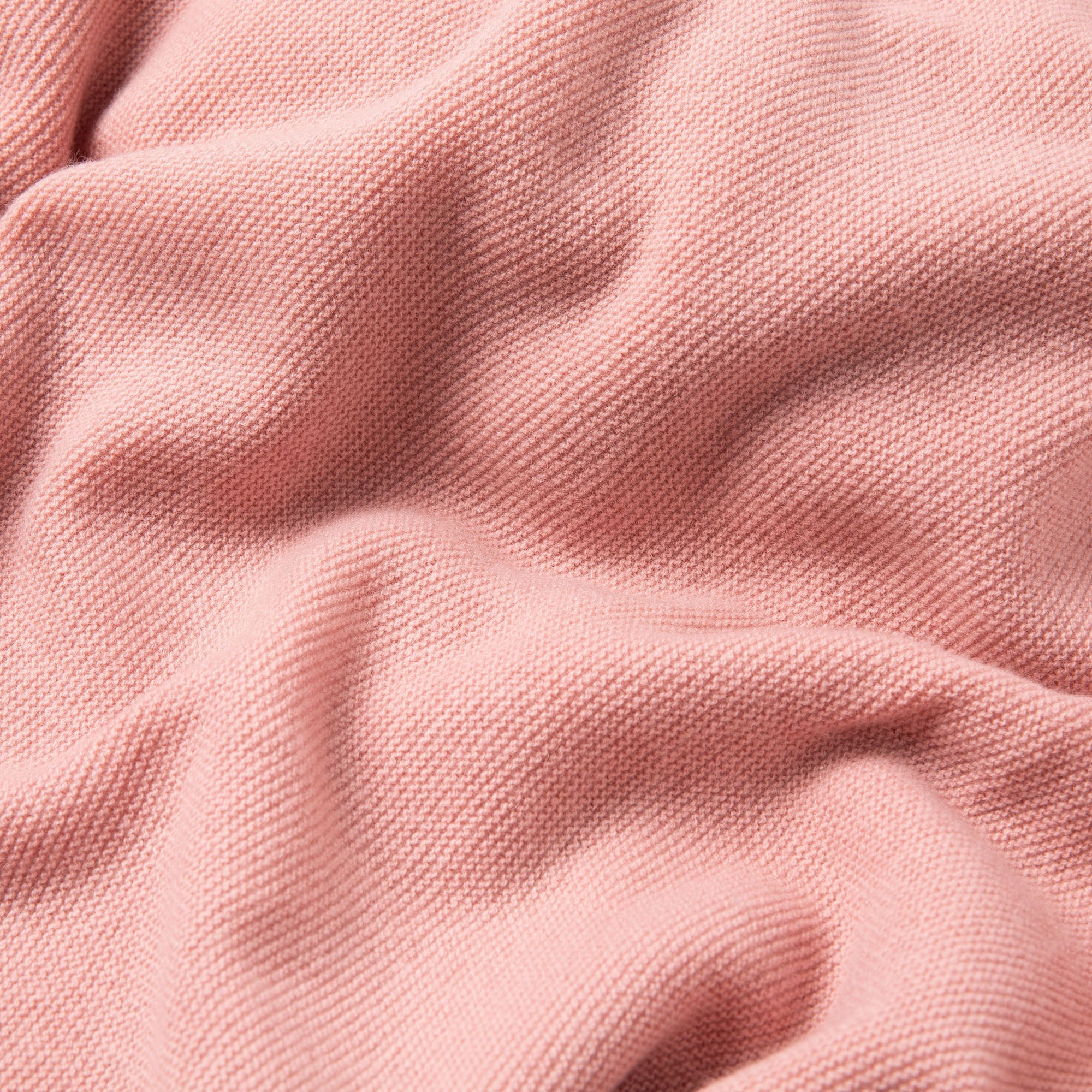 Detailaufnahme einer Wolldecke für Babys in rosa mit feinem Strickmuster