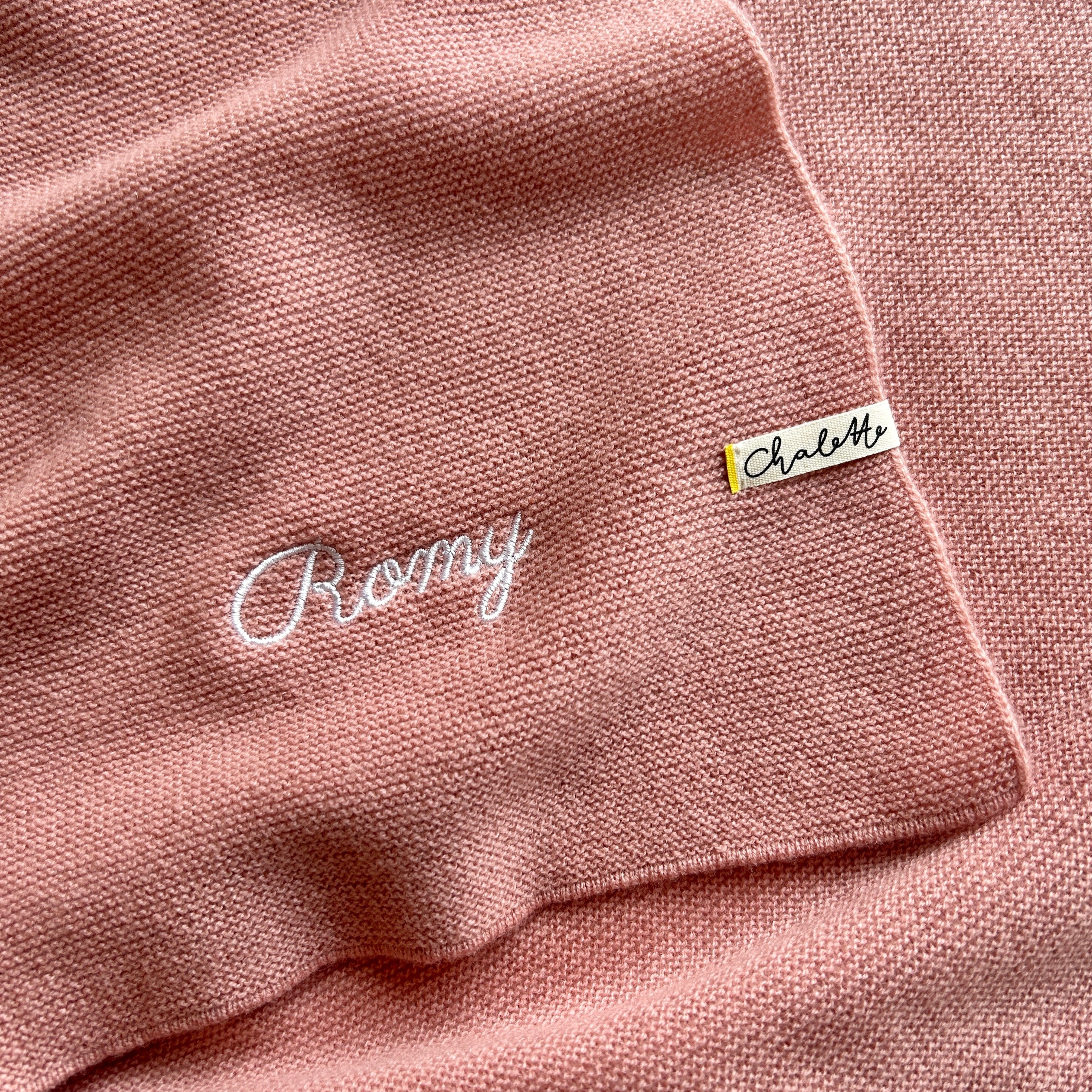 Babydecke in Hellrosa bestickt mit Namen "Romy" in Weiß.