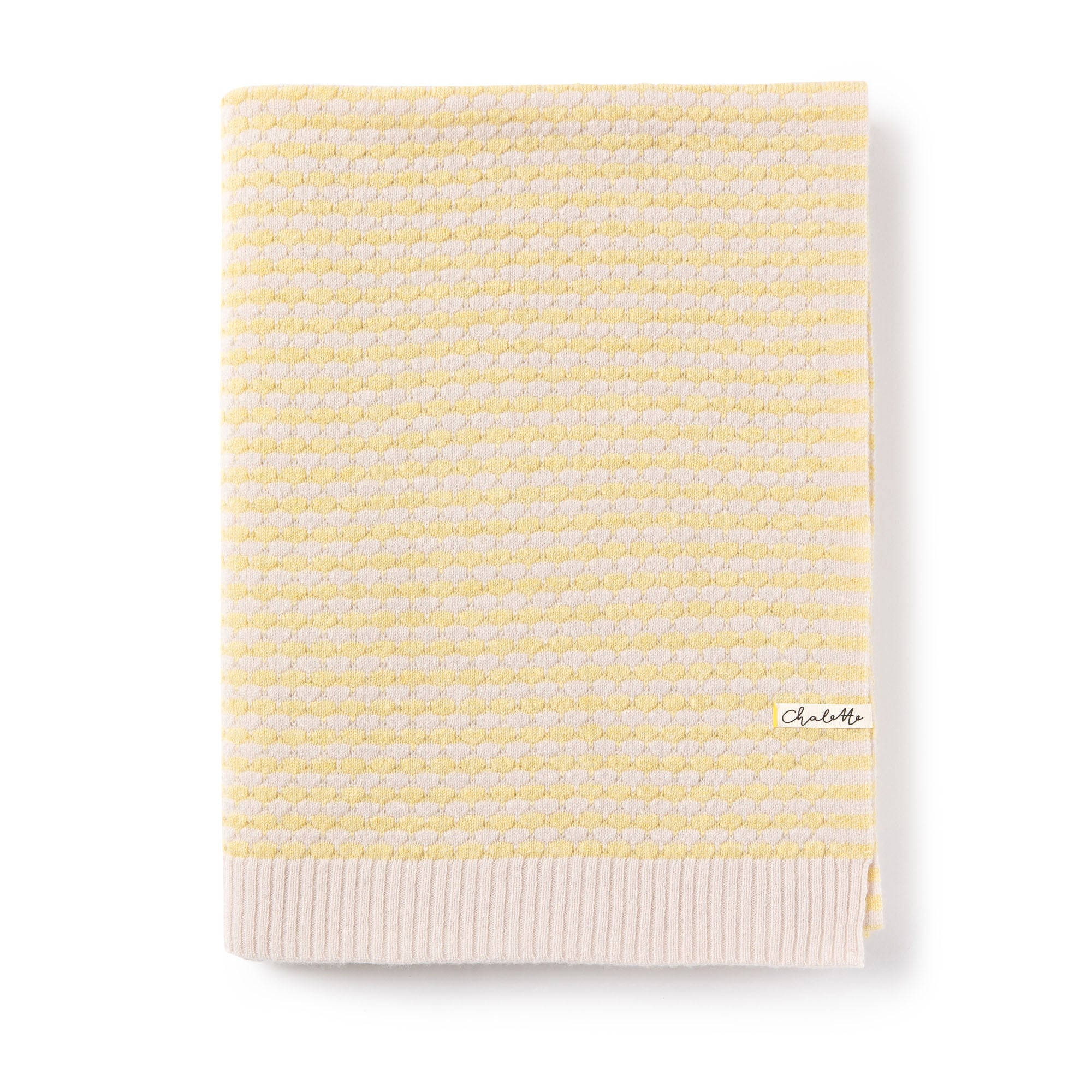 Gefaltete Babydecke mit strukturiertem Wabenmuster in Gelb und Beige, mit Chalette-Etikett