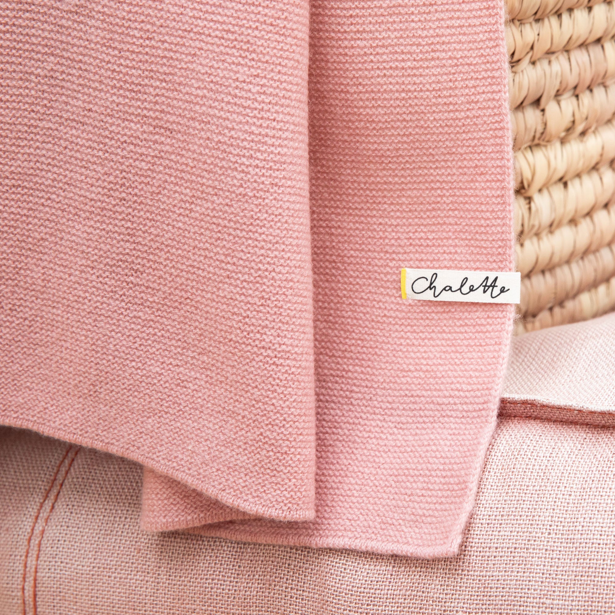 Detailaufnahme einer Babydecke aus Merinowolle und Kaschmir in rosa mit sichtbarem Etikett: Chalette