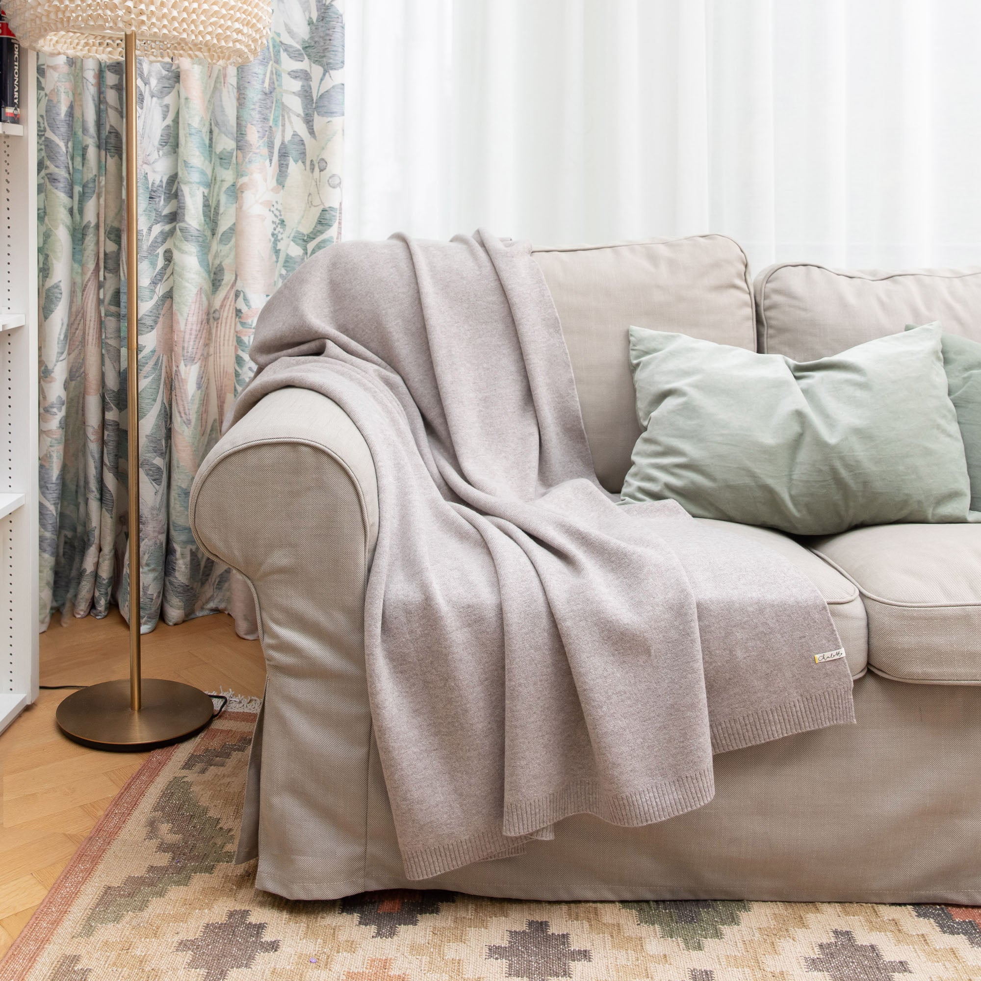 Sofadecke von Chalette in grau drapiert auf einem Sofa mit wohnlicher Dekoration