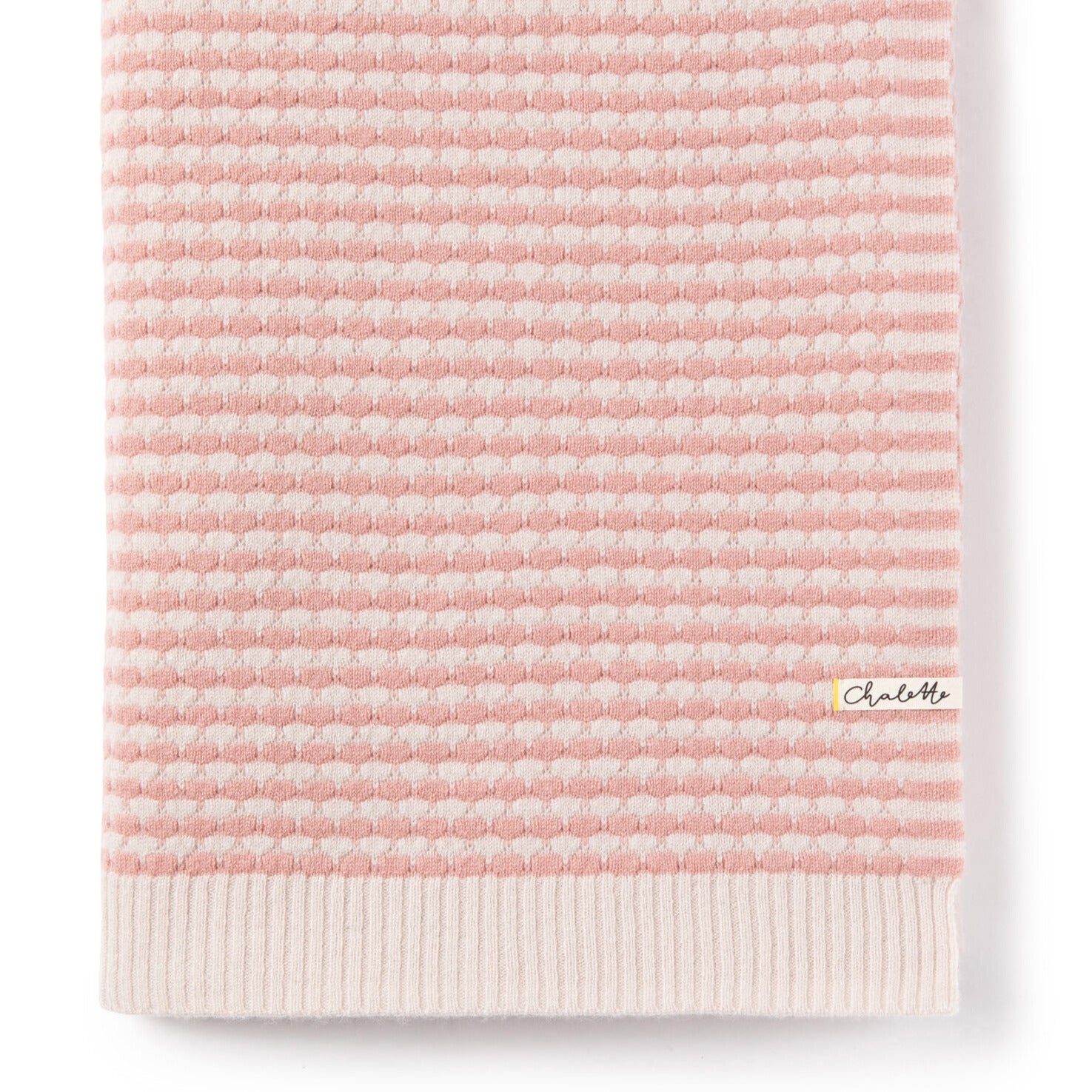 Gefaltete Babydecke mit strukturiertem Wabenmuster in Rosa und Beige, mit Chalette-Etikett