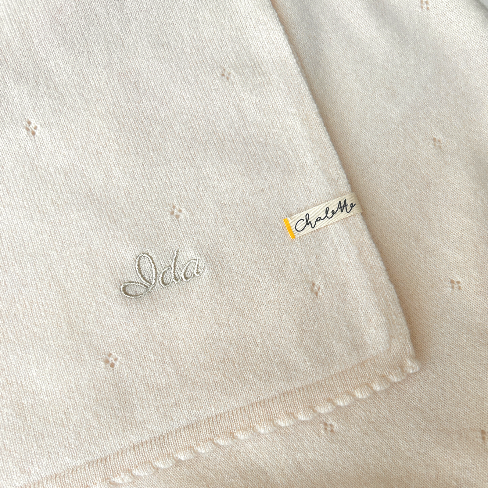 Kaschmirdecke für Babies in Off-White mit Lockmuster. Bestickt mit Namen "Ida" in Weiß.