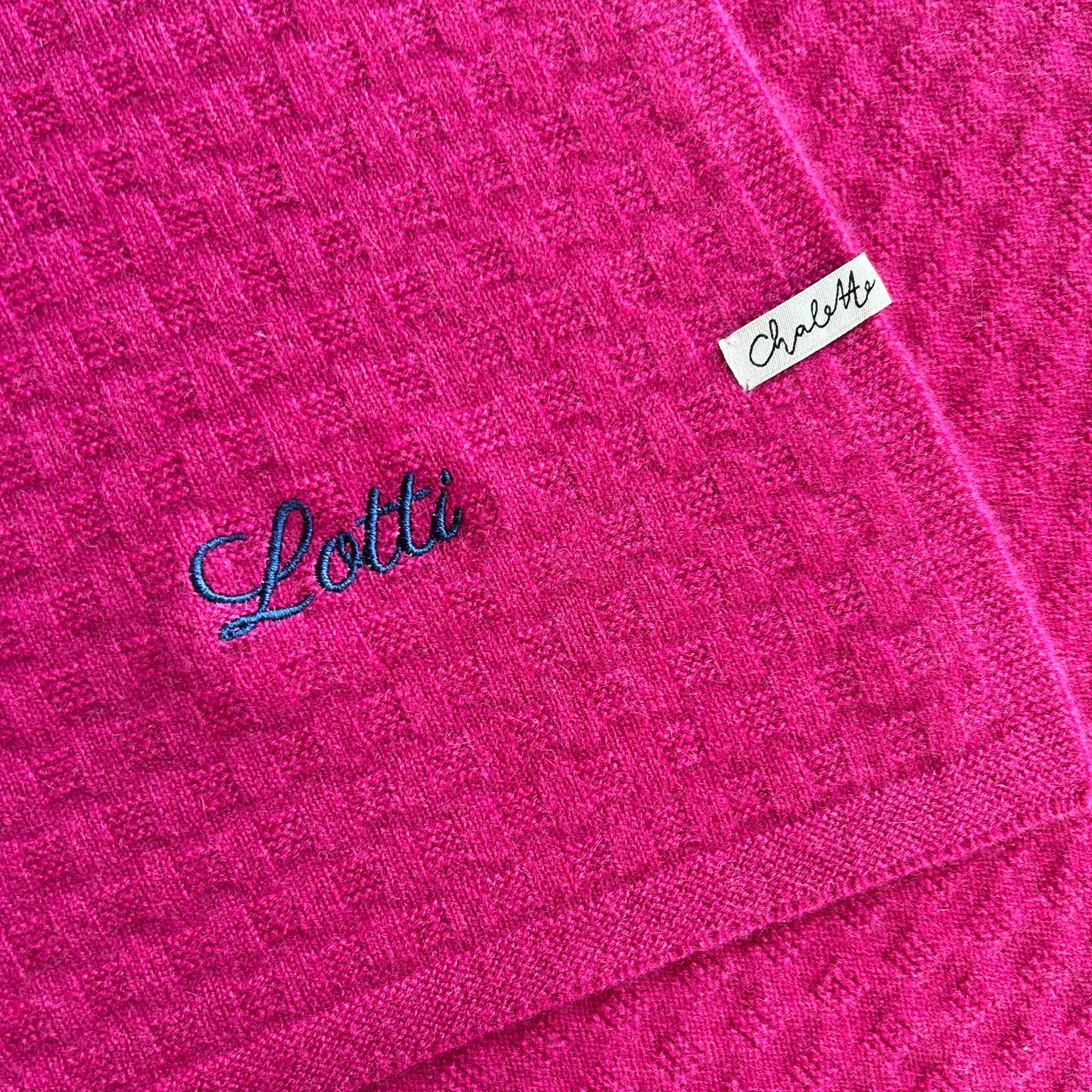 Kaschmirdecke in Rosa. Bestickt mit Namen "Lotta" in Blau