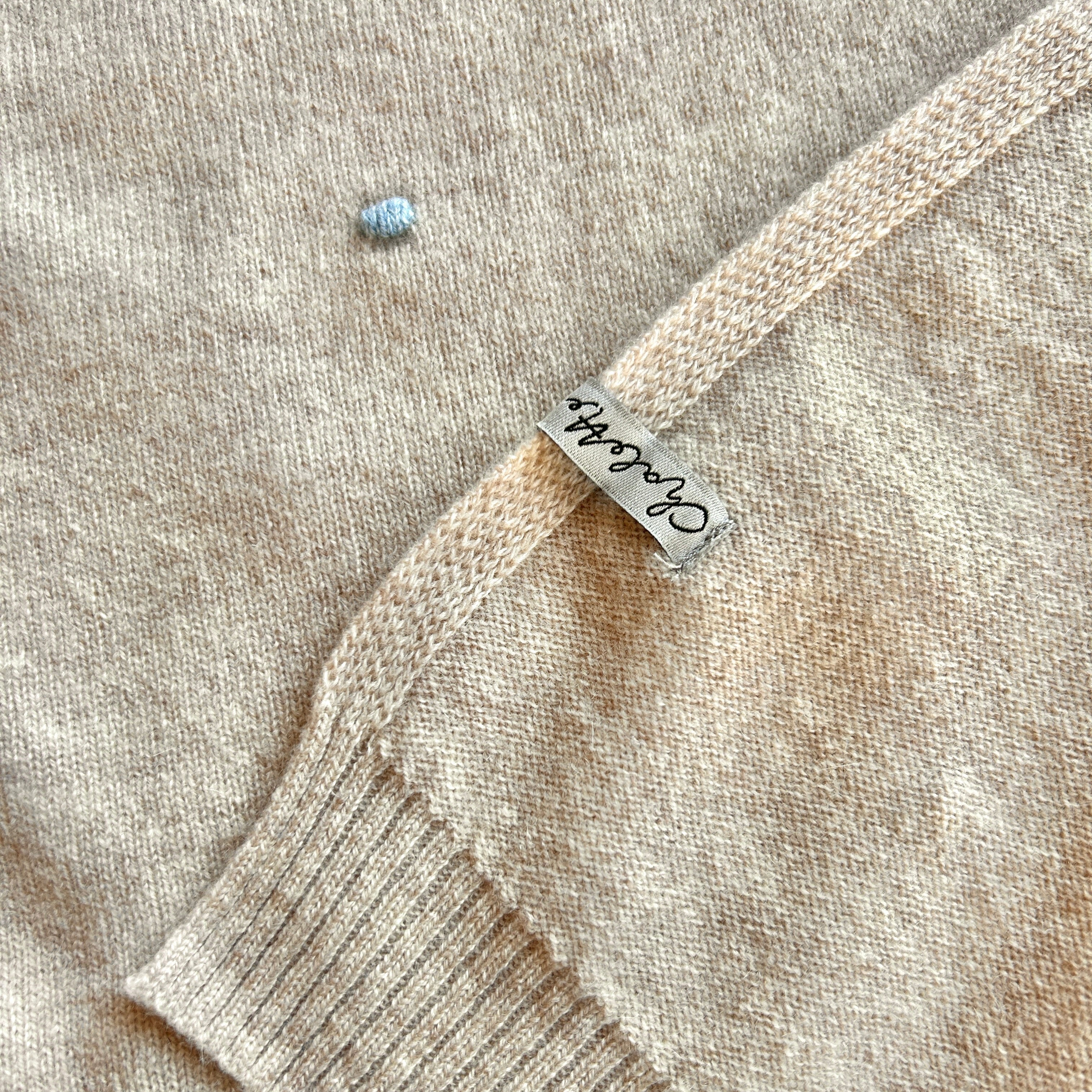 Kaschmirdecke in Beige mit Punkten in Blau.