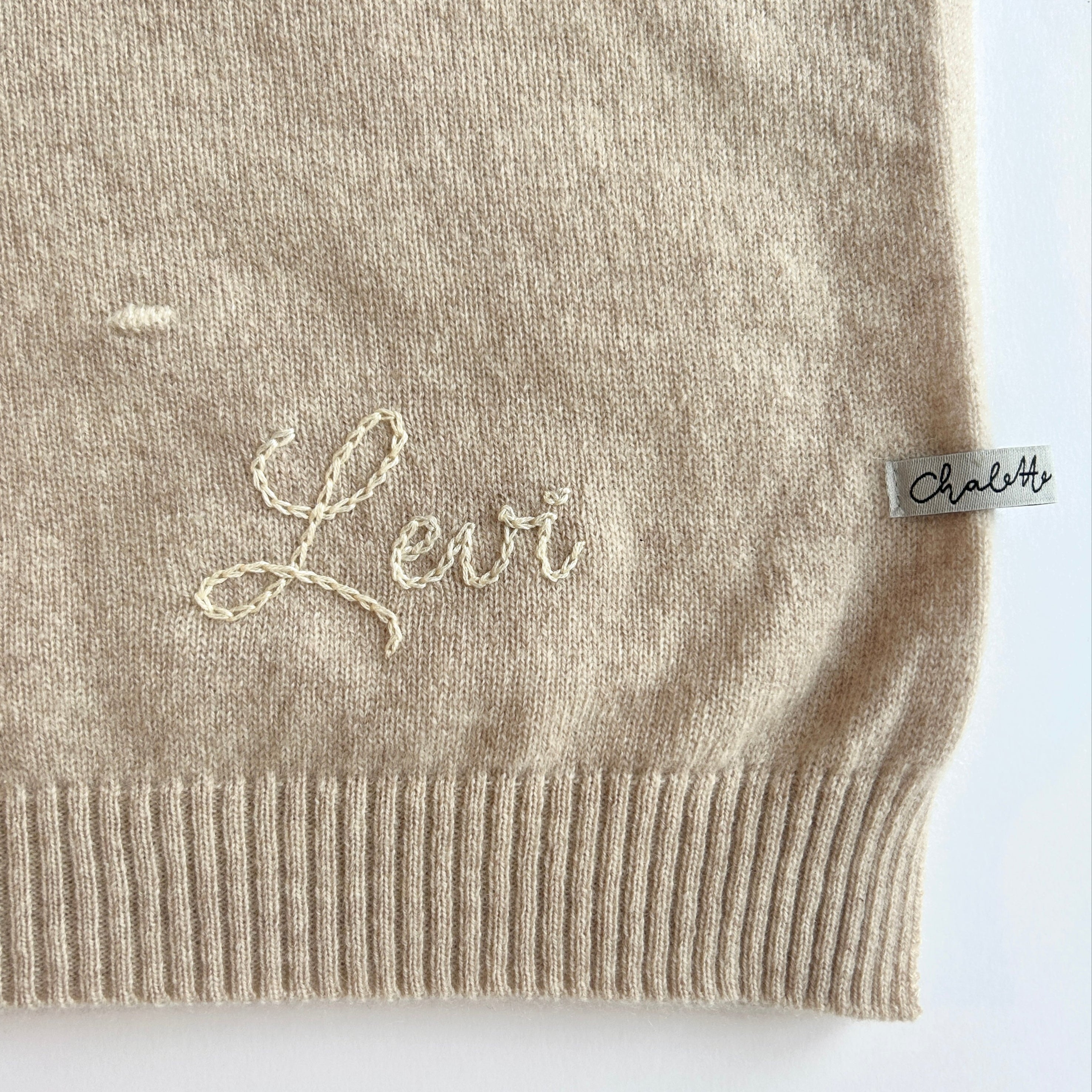 Kaschmirdecke in Beige mit Punkten in Off-White. Bestickt mit Name "Levi" mit Handstickerei in Beige.
