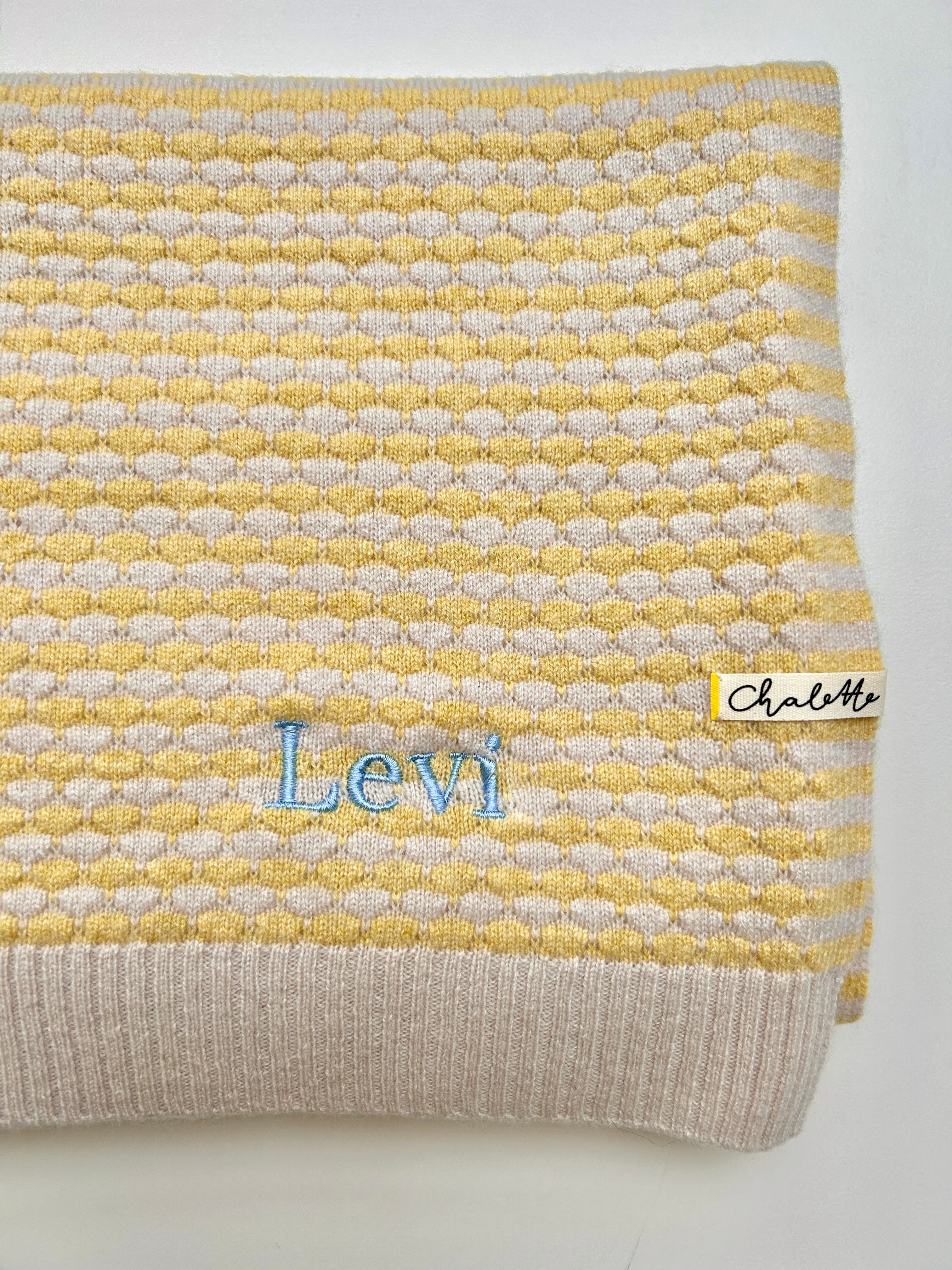 Babydecke in Beige und Gelb. Bestickt mit Name "Levi" in Blau.